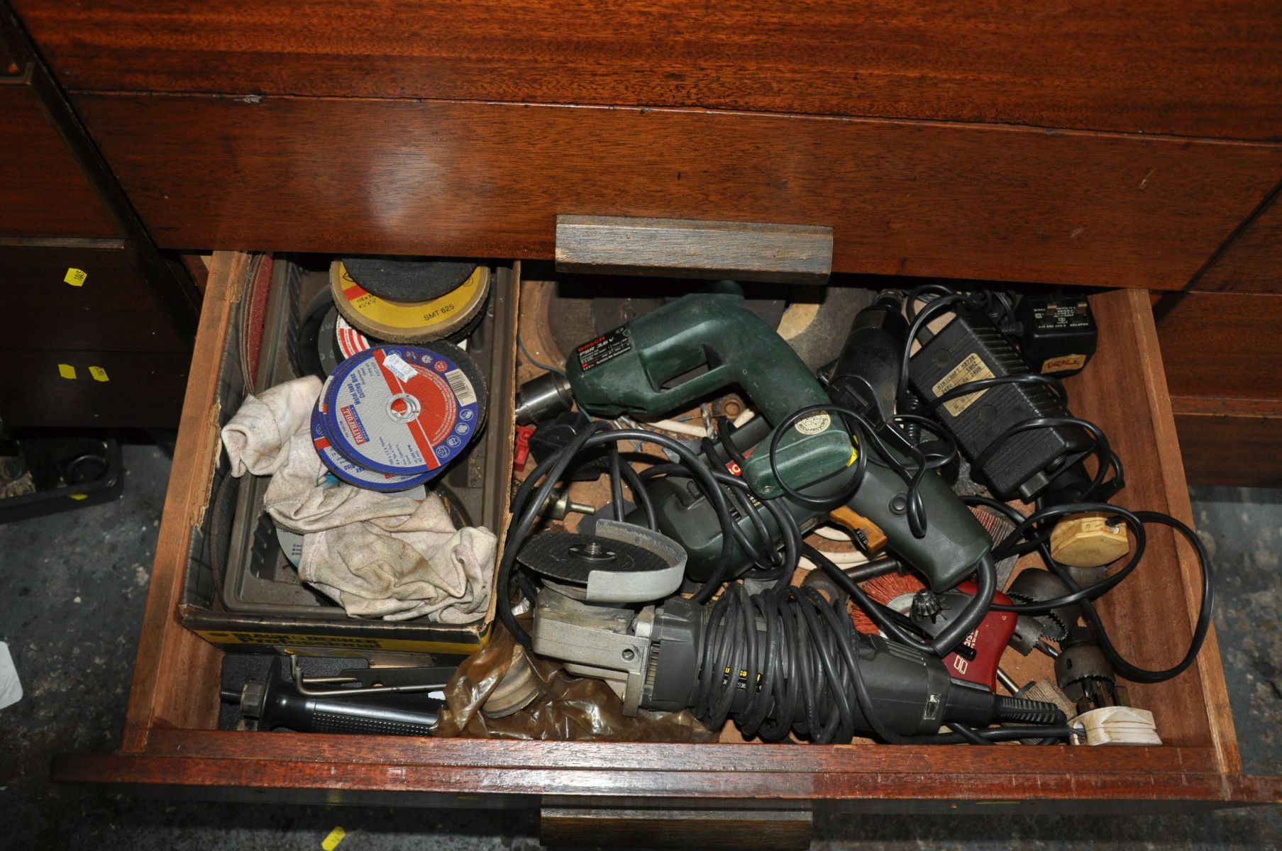 THE CONTENTS OF A DRAWER FULL OF POWER TOOLS, including a Bosch electric drill, a Black and Decker