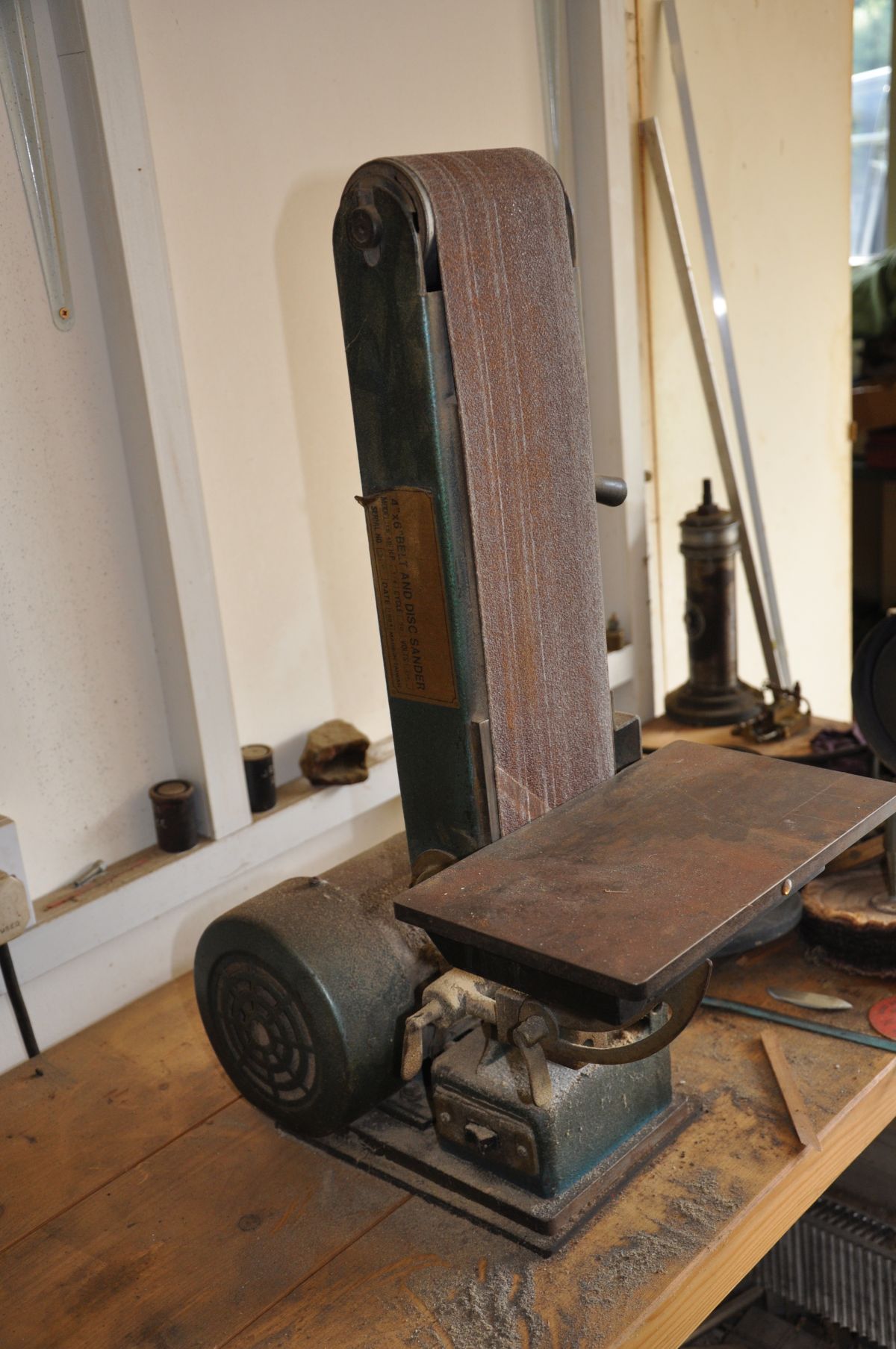 AN UNBRANDED BENCH TOP BELT SANDER, with 4''' belts (no disc sander fitted) 62cm high and a quantity