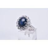 A MODERN 18CT WHITE GOLD LARGE STAR SAPPHIRE AND DIAMOND OVAL CLUSTER RING, star sapphire