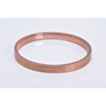 AN EARLY 20TH CENTURY ROSE GOLD SLAVE BANGLE, engine turned design, measuring approximately 78mm