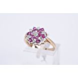 A 9CT GOLD RUBY AND DIAMOND CLUSTER RING, of tiered design, illusion set single cut diamonds and