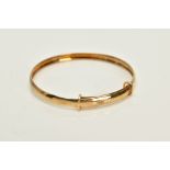 A CHILDS 9CT GOLD BANGLE, the plain polished adjustable bangle, set with a single cut diamond,