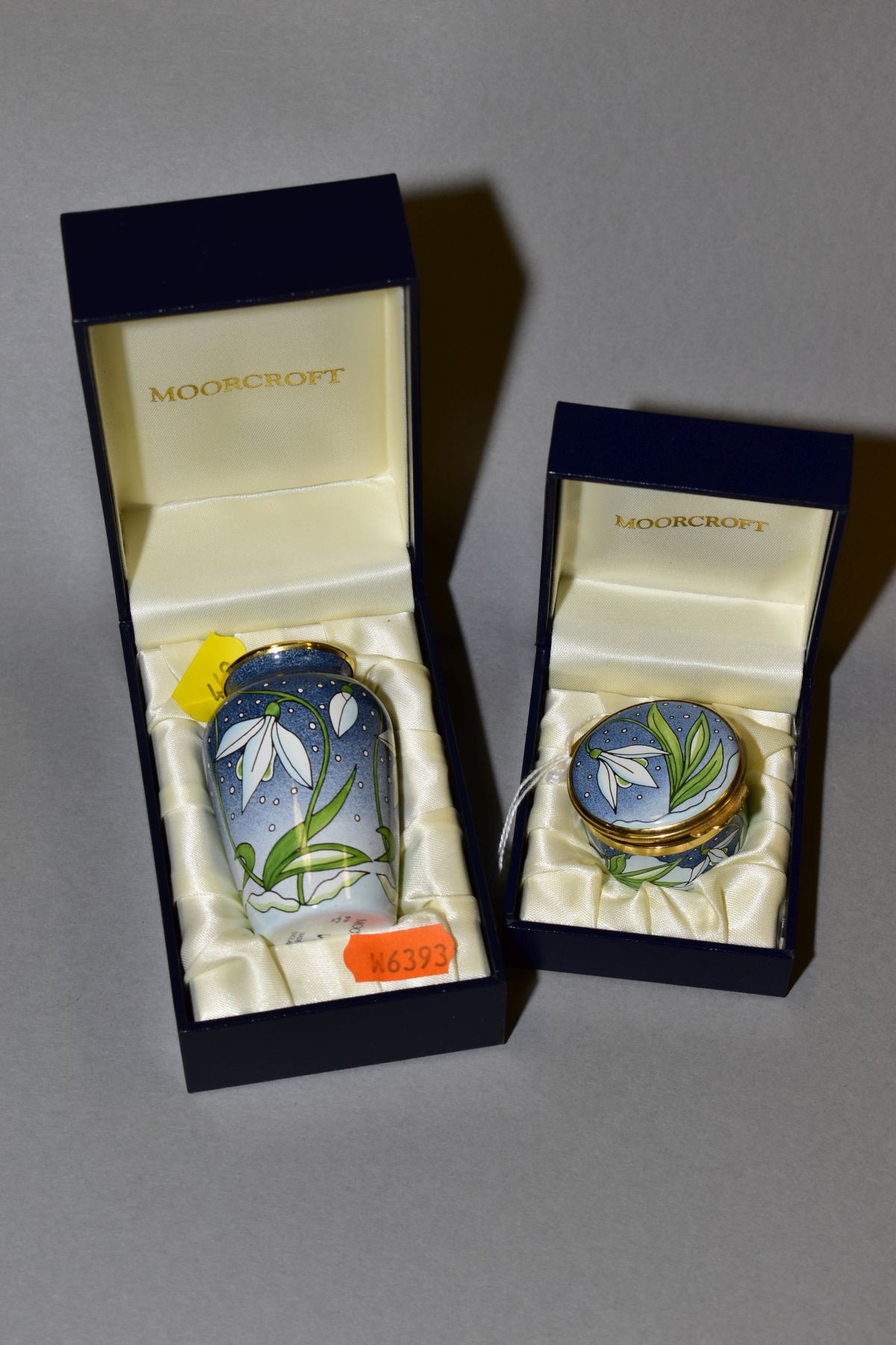 TWO BOXED MOORCROFT ENAMEL 'SNOWDROP' ITEMS, comprising of a pill box and small vase, height 7cm,