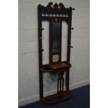 AN EDWARDIAN MAHOGANY HALL STAND, with six hooks, central mirror above a single tile and hinged