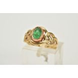 A 9CT GOLD CELTIC RING, designed with a central green stone cabochon assessed as emerald within an