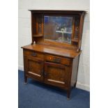 AN EARLY 20TH CENTURY OAK ARTS AND CRAFTS MIRRORBACK SIDEBOARD, the mirror back with twin foliate