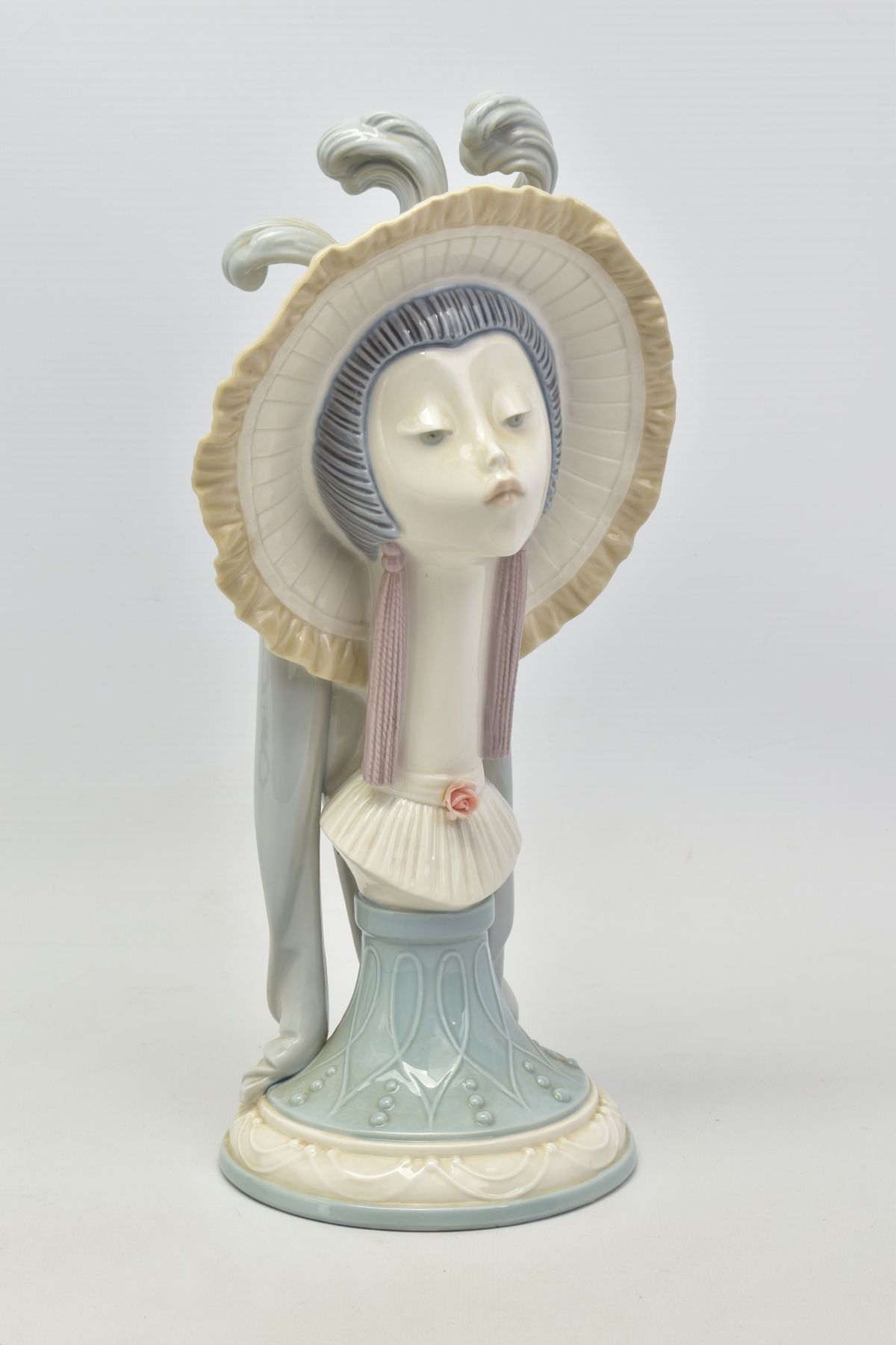 A LLADRO'S GIRLS HEAD, No.5153, depicting girls head wearing a hat with feathers on a pedestal base,