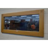 A LIGHT OAK FRAMED RECTANGULAR WALL MIRROR, 130cm x 60cm