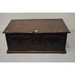 AN 18TH CENTURY AND LATER OAK BIBLE BOX, hinged cover, carved front panel on a plinth, width 74cm