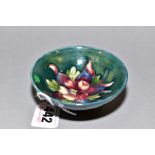A SMALL MOORCROFT POTTERY FOOTED BOWL, 'Columbine' pattern on green ground, impressed marks to base,