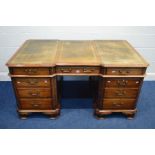 A REPRODUCTION MAHOGANY PARTNERS DESK, the top with canted corners above fretwork decoration,