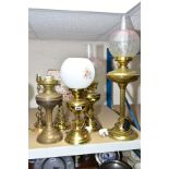 A GROUP OF SIX BRASS TABLE LAMPS, including three converted to electric oil lamps, with glass