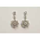 A PAIR OF DIAMOND DROP EARRINGS, each white metal earring designed with a single cut diamond stud