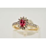 A 9CT GOLD RUBY AND SAPPHIRE CLUSTER RING, designed with a central oval cut ruby within a circular