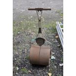 A VINTAGE CAST IRON GARDEN ROLLER badged A W Gamage, Holborn, London with a 14'' (36cm) roller