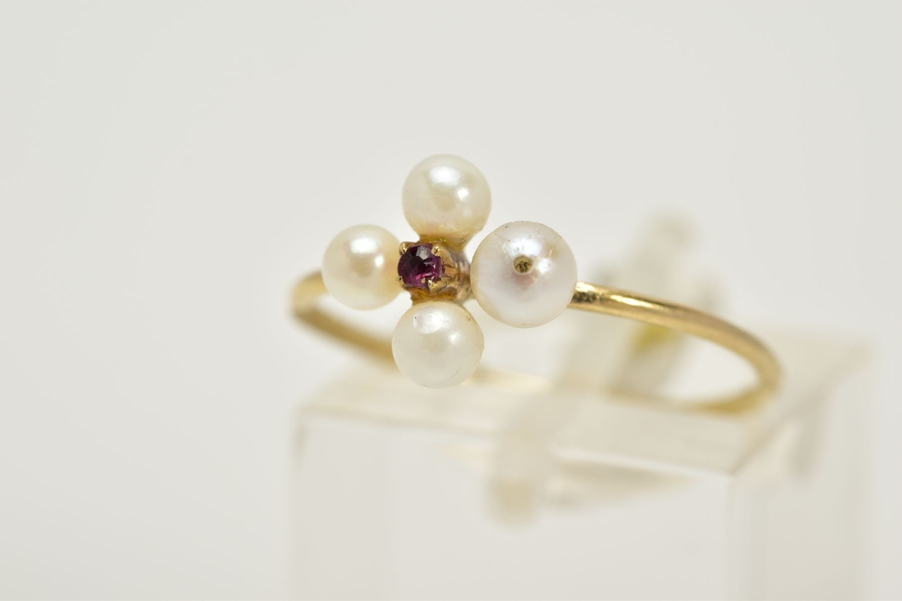 A 9CT GOLD RUBY AND PEARL RING, set with a central circular cut ruby within a four cultured pearl