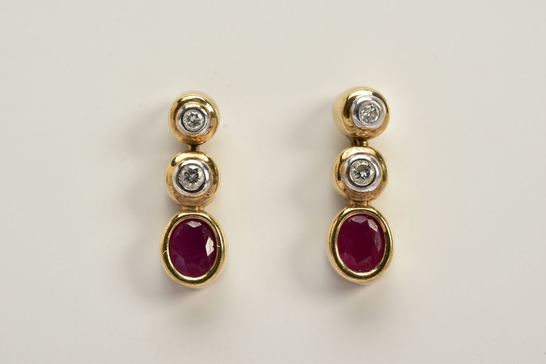 A PAIR OF 9CT GOLD DIAMOND AND RUBY DROP EARRINGS, each designed with two round brilliant cut