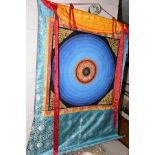 A TIBETAN THANGKA WALL HANGING CIRCA MID TWENTIETH CENTURY, the hand painted central motif is