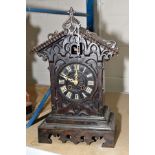 A BLACK FOREST STYLE CUCKOO MANTLE CLOCK, having Roman numerals, standing 48cm high including