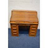AN EARLY TO MID 20TH CENTURY GOLDEN OAK ROLL TOP DESK, fitted interior (one drawer dismantled) above