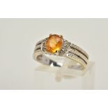 A 9CT WHITE GOLD YELLOW SAPPHIRE RING, designed with a claw set, oval cut yellow sapphire, flanked