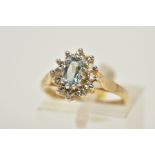 A 9CT GOLD AQUAMARINE AND DIAMOND CLUSTER RING, set with a central oval cut aquamarine within a