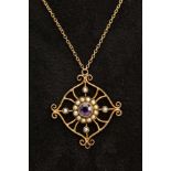 AN EDWARDIAN YELLOW METAL OPENWORK PENDANT NECKLACE, the openwork scroll detailed pendant set with a