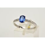 A 9CT WHITE GOLD RING, designed with a claw set oval blue stone, assessed as Kyanite, circular cut