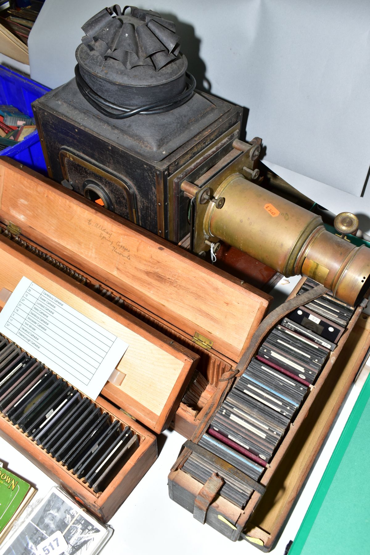 A VICTORIAN TINPLATE AND BRASS MOUNTED MAGIC LANTERN, length 59cm(sd) together with three boxes of