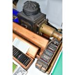 A VICTORIAN TINPLATE AND BRASS MOUNTED MAGIC LANTERN, length 59cm(sd) together with three boxes of