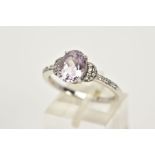 A 9CT WHITE GOLD AMETHYST RING, designed with a claw set, oval cut pale amethyst, flanked with