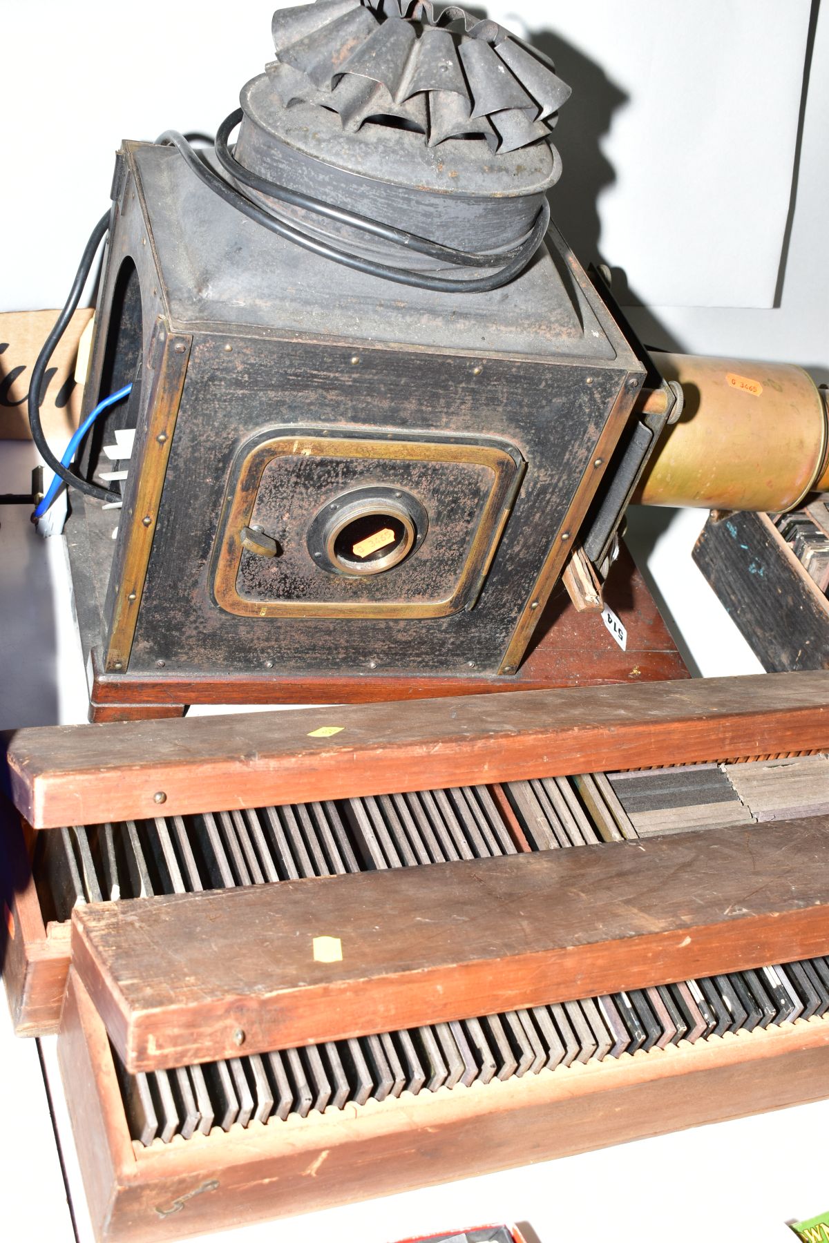 A VICTORIAN TINPLATE AND BRASS MOUNTED MAGIC LANTERN, length 59cm(sd) together with three boxes of - Image 7 of 7