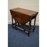 AN EARLY TO MID TWENTIETH CENTURY OAK GATE LEF TABLE with a wavy top edge on barley twist supports