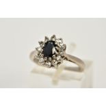 AN 18CT WHITE GOLD SAPPHIRE AND DIAMOND CLUSTER RING, designed with a central oval cut sapphire