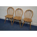 A SET OF THREE DISTRESSED ERCOL BLOND ELM AND BEECH HOOP SPINDLE BACK CHAIRS