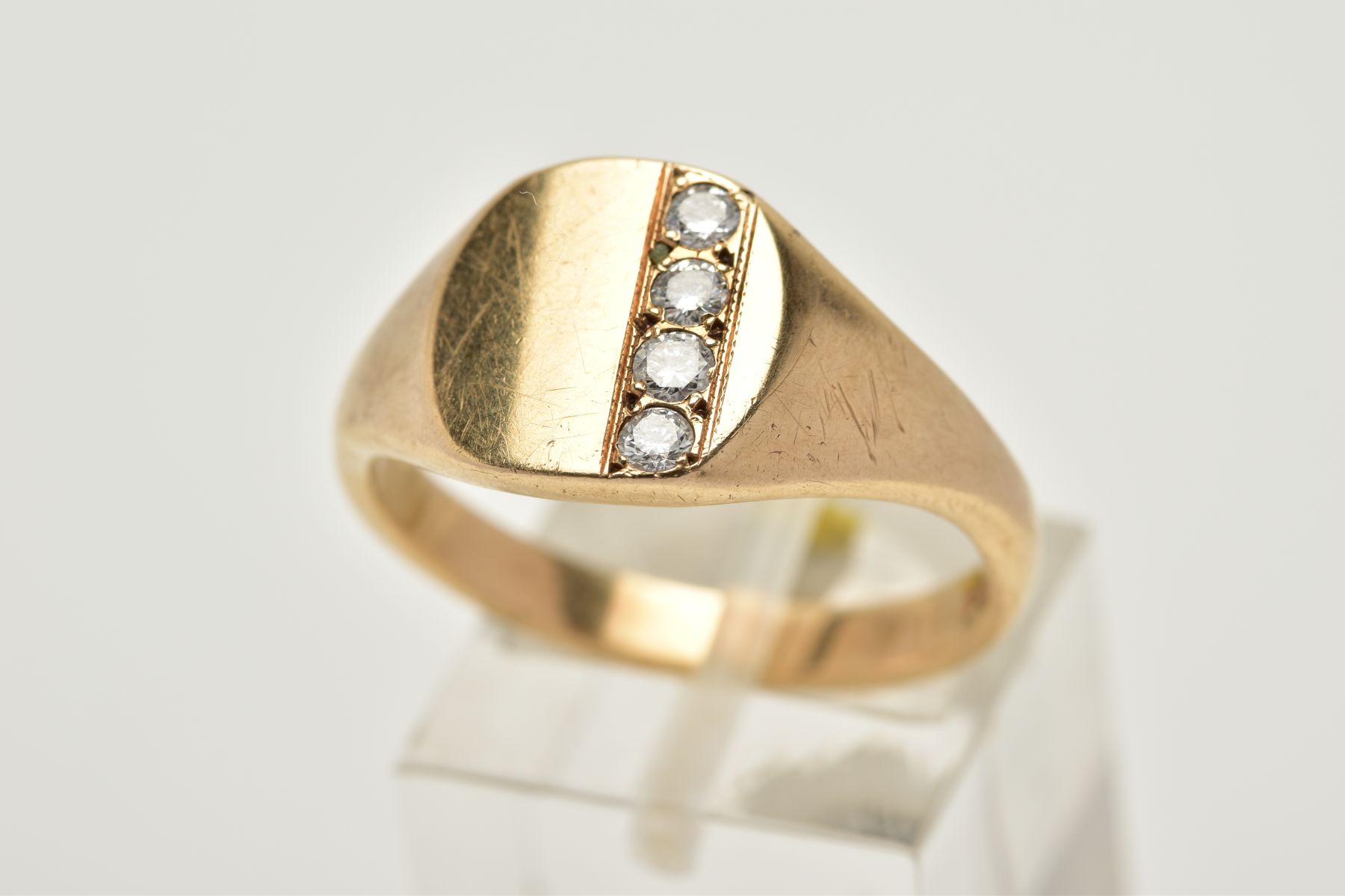 A 9CT GOLD GENTLEMANS DIAMOND SIGNET RING, the plain polished square design set with a row of