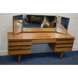 A MID TWENTIETH CENTURY TEAK DRESSING TABLE, with a triple dressing mirror and seven drawers,