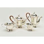 A SILVER FOUR PIECE TEA SERVICE SET, to include a silver teapot with wicker handle, a matching