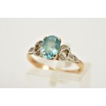 A 9CT GOLD TOPAZ RING, designed with a claw set, oval cut blue topaz, with openwork shoulders set