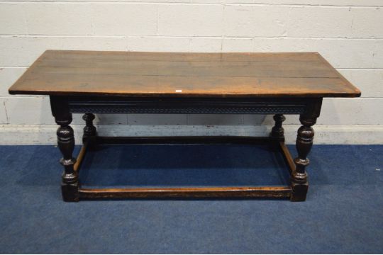 AN 18TH CENTURY OAK REFECTORY TABLE, a triple plank top, above a carved frieze, on turned and
