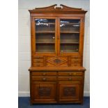 AN EDWARDIAN OAK GLAZED DOUBLE DOOR BOOKCASE, enclosing three adjustable shelves, above two banks of