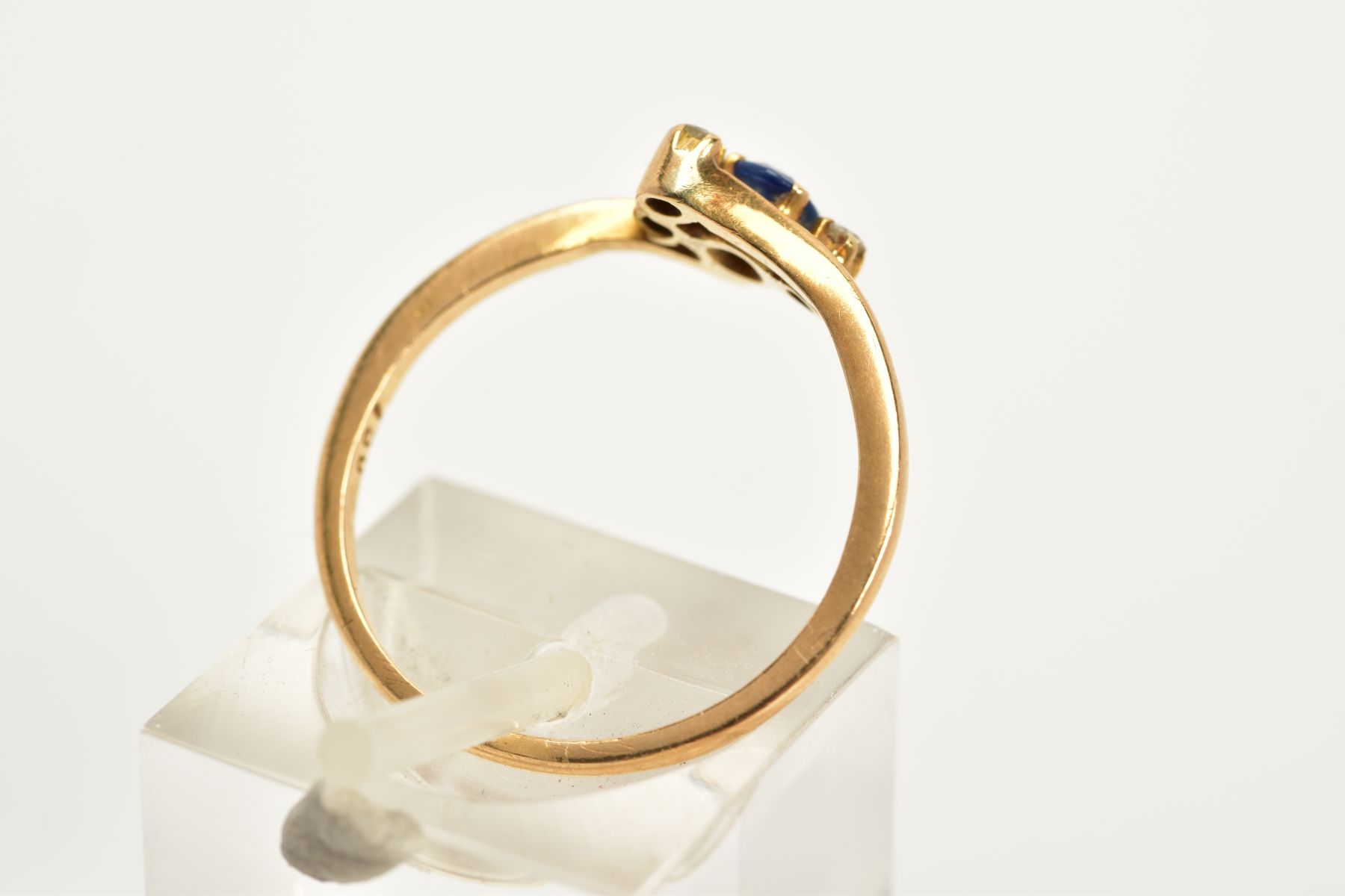 A SAPPHIRE AND DIAMOND YELLOW METAL RING, of cross over design set with an oval cut sapphire flanked - Image 3 of 3