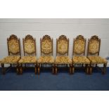 A SET OF SIX OAK DINING CHAIRS with a carved coat of arms top rail and lions heads to knees