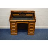 AN EARLY TO MID 20TH CENTURY OAK ROLL TOP DESK, stamped Angus London, with an assortment of internal