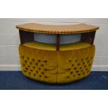 A MID 20TH CENTURY CURVED DRINKS BAR, with a teak finish top, buttoned velvet front, and various