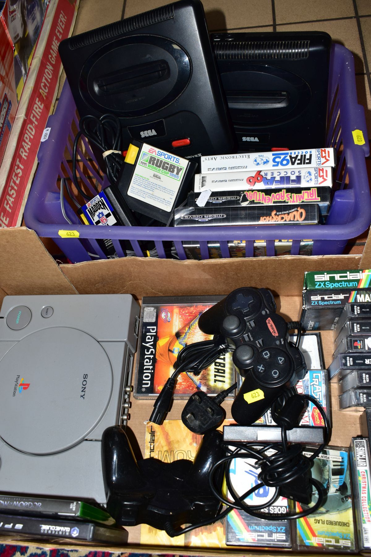TWO TRAYS, containing Sony Playstation. two controllers and games, two Sega/Mega Drive II machines