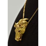 A MODERN HORSE HEAD PENDANT, realistically stylized, textured finish with ruby eyes, pendant