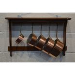 A SET OF FIVE EARLY 20TH CENTURY COPPER GRADUATING PANS with brass hooped handles