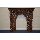 A HEAVILY CARVED AND PIERCED FIRE SURROUND, with foliate fruiting vine decoration, flanked by