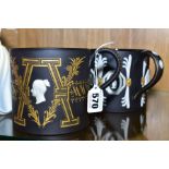 TWO LIMITED EDITION WEDGWOOD BLACK BASALT COMMEMORATIVE MUGS, both designed by Richard Guyatt, '